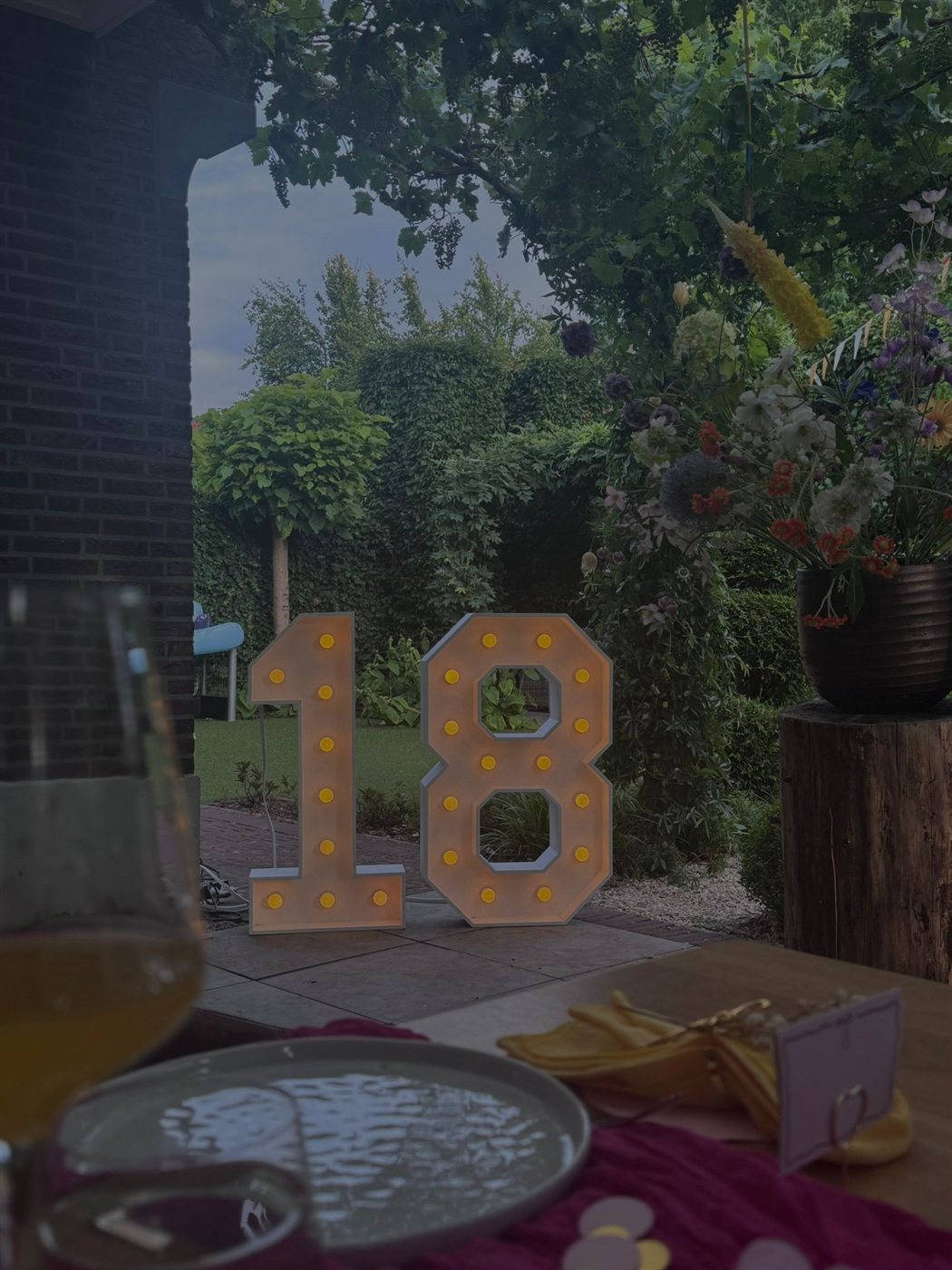 Lichtcijfer 18 in de tuin bij kaarslicht